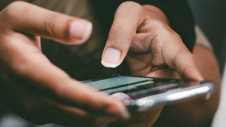 une personne discute avec une messagerie instantanée sur son smartphone