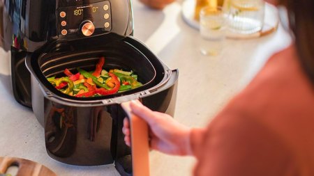 Une femme cuit des poivrons au Air Fryer