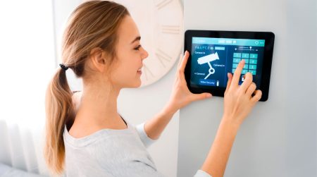 Devez-vous acheter une alarme et une caméra de sécurité cet été ? Une femme installe une alarme chez elle