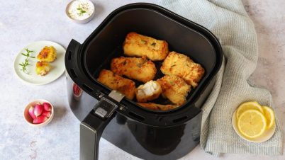 Air Fryer : les aliments à ne surtout pas cuire congelés bac d'un air fryer avec des aliments autour